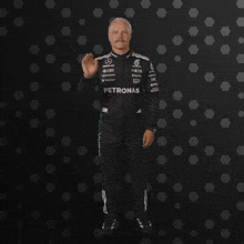 a man in a petronas suit giving a high five