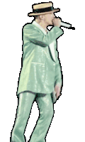 a man in a green suit and straw hat singing into a microphone