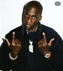 a man wearing a black jacket is giving the middle finger and has the number 7/15 on the bottom right