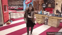 a woman is dancing in a room with a red and white striped floor