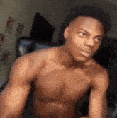 a shirtless young man is sitting in a chair .