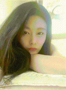 a woman laying on a bed with her head resting on her hand .