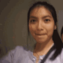 a woman wearing headphones and a purple shirt is giving a thumbs up