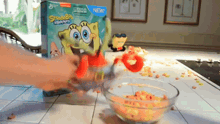a box of spongebob squarepants cereal is being poured into a glass bowl