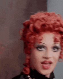 a close up of a woman 's face with red hair and makeup
