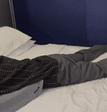 a man in a suit is laying on a bed with his legs crossed