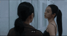 two women are looking at each other and one of them says je-yi on the screen