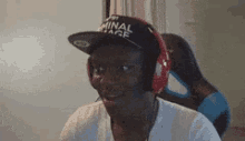 a man wearing a baseball cap and headphones is sitting in a chair .