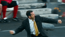 a man in a suit and tie is dancing on the ground