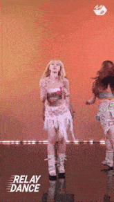 a woman in a pink top and white skirt is dancing on a stage with relay dance written on the bottom