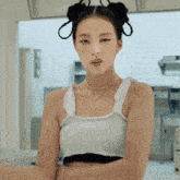 a woman with two buns in her hair is wearing a white top