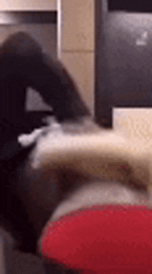 a blurry picture of a person sitting on a couch with a laptop in the background .