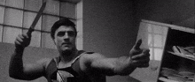 a man is holding a knife and giving a thumbs up .