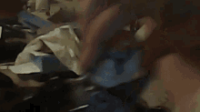 a messy room with a lot of clothes on the floor and a person laying on a bed .