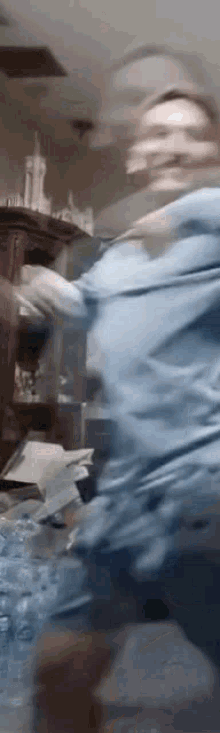 a blurry picture of a person in a blue shirt standing in a room