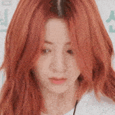 a close up of a woman with red hair looking down