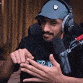 a man wearing headphones and a hat has the letter fn on his hat
