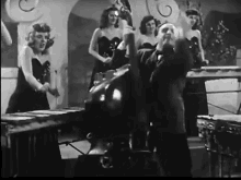 a black and white photo of a man playing a piano