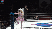 a woman in a pink outfit is in a wrestling ring with #senjo written on the bottom