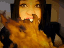 a close up of a woman eating a piece of food with a surprised look on her face