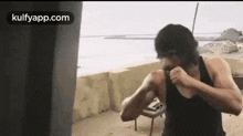 a man is boxing in front of a punching bag on a rooftop .