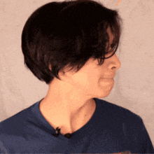 a woman wearing a blue shirt with a microphone on her neck