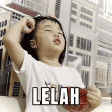 a little girl with her eyes closed and the word lelah written on her shirt
