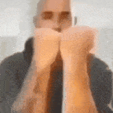 a blurry picture of a man in a suit and tie holding his fist up .