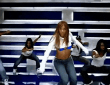 a group of women are dancing on a bleacher in a gym .