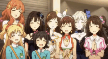 a group of anime girls are posing for a picture and smiling for the camera .