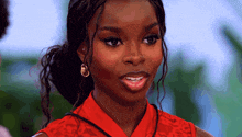a close up of a woman wearing a red shirt