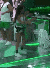 a group of people are dancing on a stage in a club .
