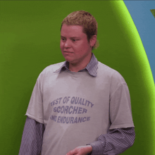 a man is wearing a t-shirt that says test of quality scorcher and endurance