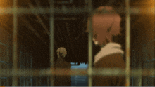 a man in a hoodie is behind bars and looking out