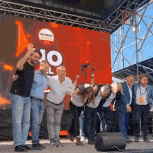 a group of people are standing on a stage in front of a large screen that says 10