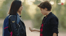 a boy and a girl are standing next to each other with trt1 written on the bottom of the screen