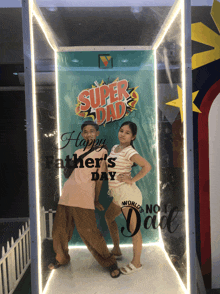 a boy and a girl pose in front of a super dad sign
