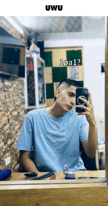 a young man is taking a picture of himself in a mirror with a caption that says uwu