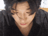 a close up of a person 's face with their eyes closed and their hair blowing in the wind .