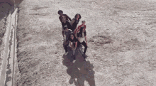 a group of young people are posing for a picture in a dirt field .