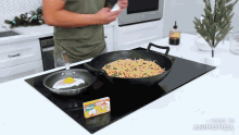 a man is cooking noodles in a wok on a stove top with a box of knorr noodles in front of him