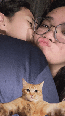 a man and woman kissing with a cat between them
