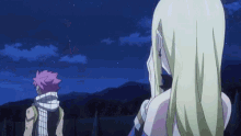 a man and a woman are standing next to each other in front of a blue sky .