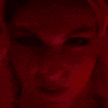 a close up of a person 's face in a purple and red painting