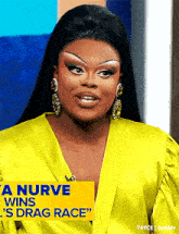 a woman is wearing a yellow dress and earrings and a sign that says a nurve wins ' s drag race '