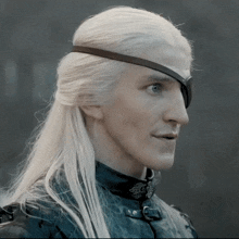 a man with long white hair has a black eye patch