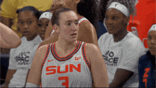 a female basketball player wearing a white sun jersey