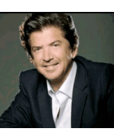 a man wearing a suit and white shirt smiles for the camera