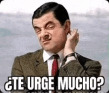 mr bean is wearing a suit and tie and making a funny face with the words `` te urge mucho '' written on it .