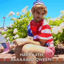 a man in an american flag outfit is sitting on a brick wall with flowers in the background